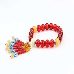 Detailed view of red and yellow crystal car hanging ornament with tassel and beads