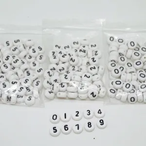 Acrylic number beads detail shot showing white round beads with black digits from zero to nine.