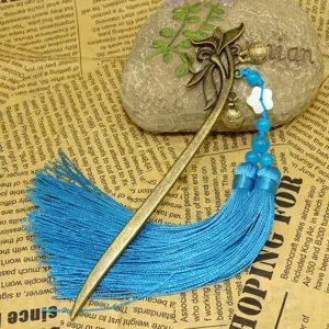 Segnalibro vintage in bronzo con nappe blu, fiore di conchiglia e perline per lettura.