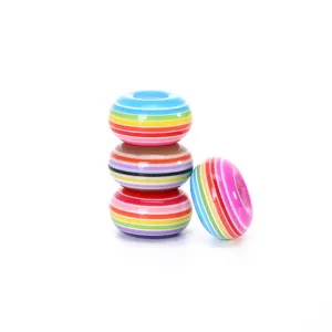 Close-up detail of colorful striped resin barrel beads, perfect for DIY jewelry making.