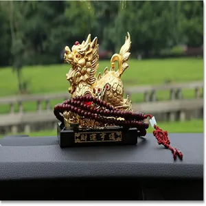 Vista di dettaglio di ornamento Pixiu dorato e perle di preghiera in legno rosso