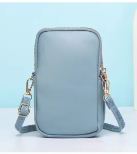 Light blue vertical phone bag detail shot, PU leather mini crossbody bag with metal zipper.