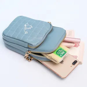 Blue quilted crossbody phone bag with floral embroidery and multi-pocket zipper design.