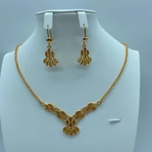 Gedetailleerd overzicht van vintage gouden ketting en oorbellen set met filigrain.