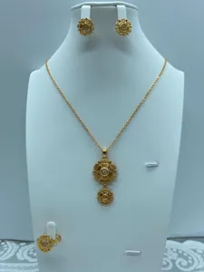 Gedetailleerd overzicht van vergulde vintage sieradenset met bloemenhanger ketting en oorbellen.