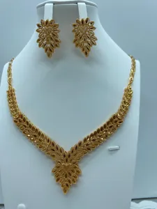 Gedetailleerd overzicht van vintage vergulde ketting en oorbellen sieraden set met goud.