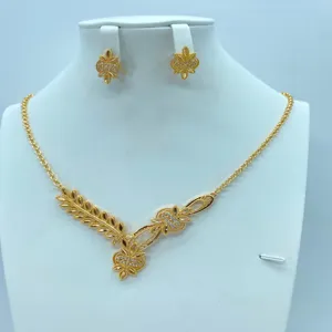 Gedetailleerd overzicht van de vergulde vintage blad ketting en oorknopjes sieradenset.