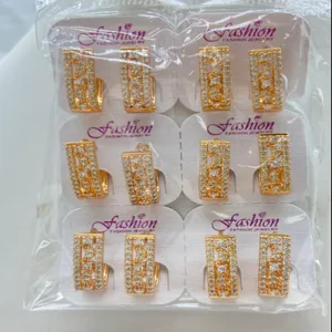 Detailed shot of gold-plated geometric zircon hoop earrings in wholesale pack, shiny detail.
