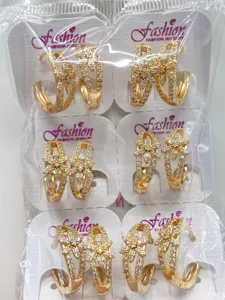 Detailansicht goldiger Blumen-Creolen mit funkelndem Zirkonia in transparenter Verpackung.