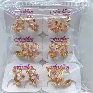 Detailaufnahme eleganter kupfervergoldeter Ohrringe mit rosa Zirkoniasteinen auf Displaykarten.