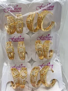 Nahaufnahme Detail goldfarbener Zirkon Creolen in transparenter Großhandelsverpackung.