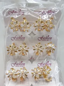 Detailaufnahme von funkelnden Zirkonblüten-Ohrringen in Goldton auf Displaykarten.