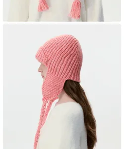 Pink winter knitted trapper hat with braided tassels, warm wool blend ear protection detail.