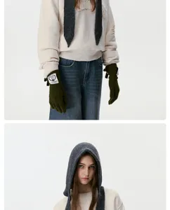 Detailed view of cozy knitted hooded scarf and green gloves, showing fine knit texture.