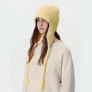 Winter warm knitted earflap hat with braided ties for women, cozy windproof fleece beanie.