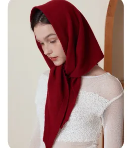 Close-up view of a wine red cashmere knitted triangular scarf, warm autumn winter wear.