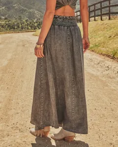 Close-up view of the vintage grey acid-wash denim maxi skirt featuring a smocked high waist.