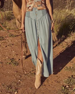 Light blue denim maxi skirt featuring high waist smocked design and front button closure.