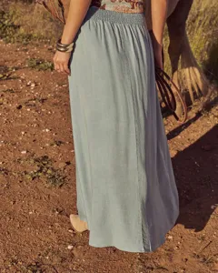 Outdoor lifestyle detail view of light blue bohemian maxi skirt with elastic high waist.