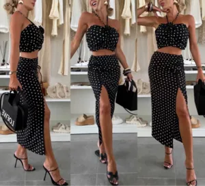 Detailed view of the black polka dot crop top and side slit skirt in a stylish boutique setting.