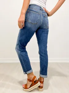 Back view detail of blue washed skinny denim jeans with cuffed hems and mid-waist fit.