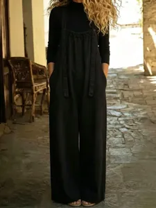 Detalle de un cómodo peto holgado de mezclilla negra para mujer con un estilo vintage.