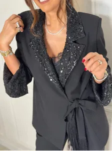 Close-up detail of women's black sequin patchwork long sleeve blazer with tie belt.