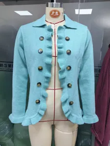 Close-up detail of light blue knitted cardigan showcasing elegant ruffles and front buttons.
