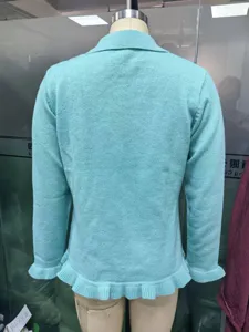 Women solid color long sleeve ruffled knit cardigan, detailed back view showing the hem.
