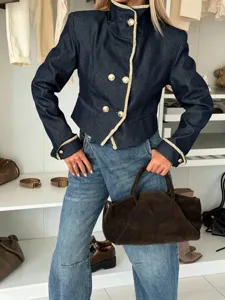 Gedetailleerd overzicht van het korte spijkerjack met Napoleon kraag en gouden knopen.