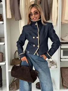 Detail van stijlvolle donkere denim jas met opstaande kraag, contrastrand en gouden knopen.