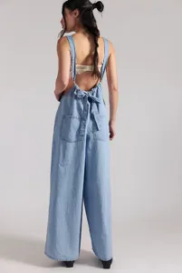 Detailed back view of light blue denim jumpsuit, featuring cute bow tie and wide leg design.