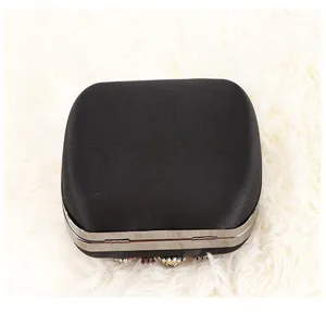 Detail view of black satin evening clutch bag with rhinestone and metal frame decorations.