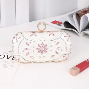 Elegant white evening clutch bag with sparkling pink rhinestones and a unique ring clasp.