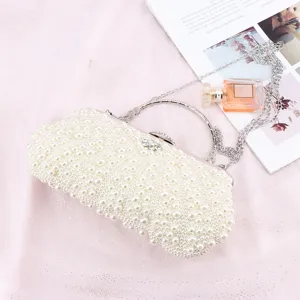 Elegant pearl clutch bag with metallic ring handle and chain strap, perfect for evening parties.
