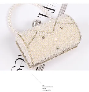 Elegant pearl evening clutch bag with pearl handle and metal clasp for luxury events.