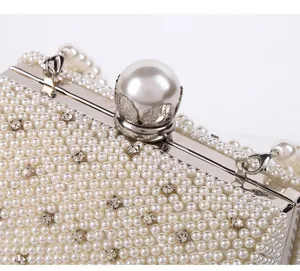Pearl evening clutch bag detail shot, elegant bridal handbag with shiny rhinestones and clasp.
