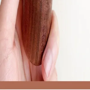 Close-up detail of black walnut wood bottle opener handle, smooth natural wood grain.