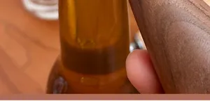 Close up detail view of wooden handle bottle opener showing premium texture and ergonomic grip.