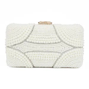 Close-up detail of white pearl evening clutch bag with sparkling rhinestone clasp design.