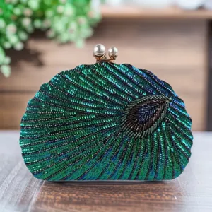 Detailed close-up shot of exquisite peacock pattern sequin evening clutch with pearl clasp.