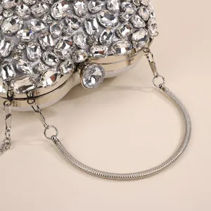 Close-up detail of luxury rhinestone crystal evening clutch bag with elegant metal handle.
