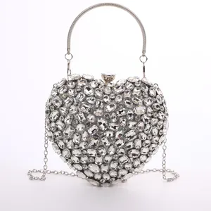 Close-up detail of the sparkling crystal heart evening bag with silver chain strap.