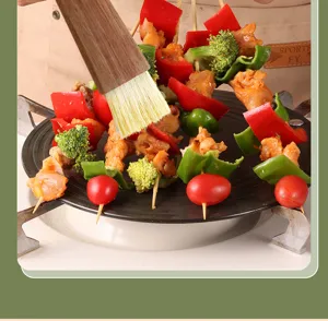 Wooden handle pastry basting brush detail applying cooking oil on grilled food skewers.