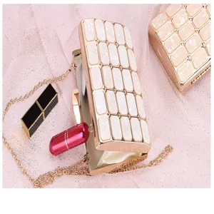 Close up of luxury acrylic evening clutch bag with metallic chain and geometric pattern.