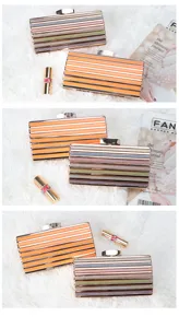Detailed view of striped evening clutch bags with metallic frame and gorgeous design.