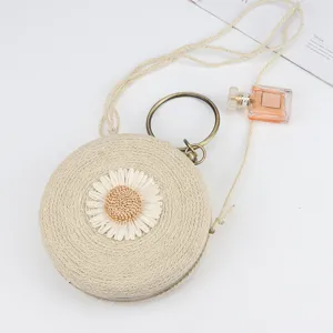 Handmade round straw woven bag with cute daisy motif, metal ring handle, casual beach bag.