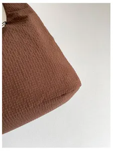 Detailed shot of a brown textured hobo shoulder bag showing its casual fabric material.