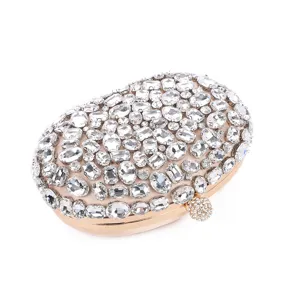 Close-up of luxury oval rhinestone evening clutch bag with sparkling crystal details and gold frame.
