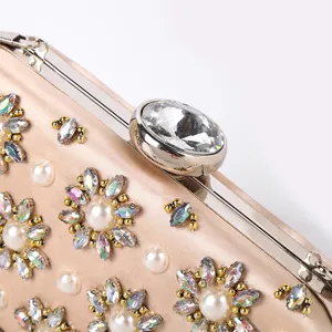 Champagne satin evening clutch bag with crystal clasp and rhinestone floral pearl details.